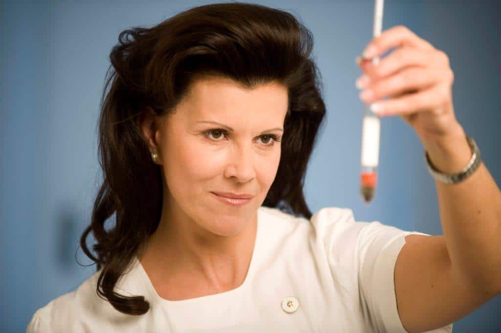 Prof. Frauwallner betrachtet konzentriert eine medizinische Probe in einer Ampulle