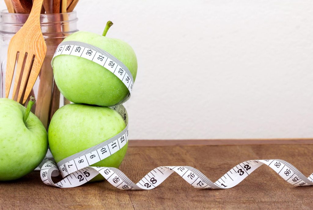 Grüne Äpfel mit Maßband – Symbol für gesunde Ernährung und bewussten Lebensstil